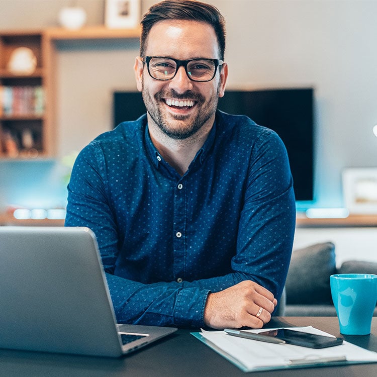 A happy looking manager in his office.