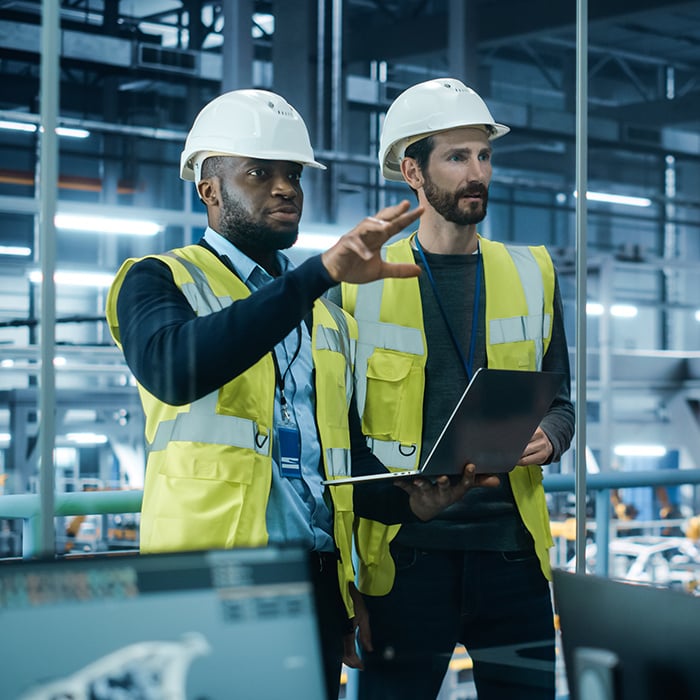 Two warehouse workers looking at the sales-to-production process.