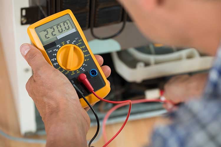 Electrical meter in an electricians hand. 