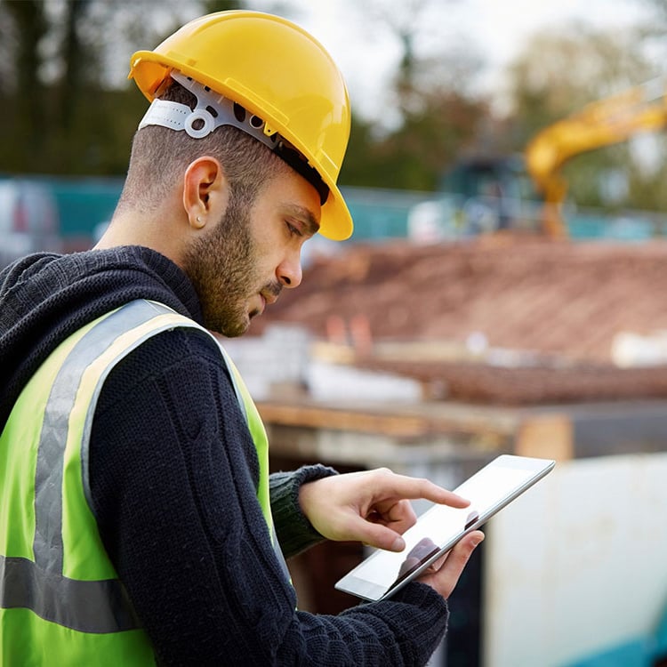 A handyman onsite working on an ipad.