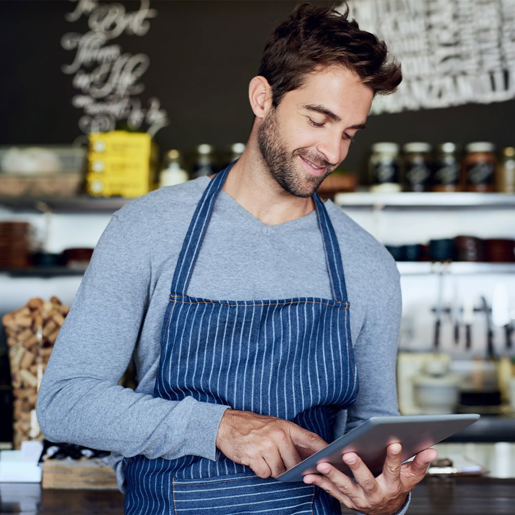 Small business, cafe and man with tablet checking review, online booking or reservation in coffee shop