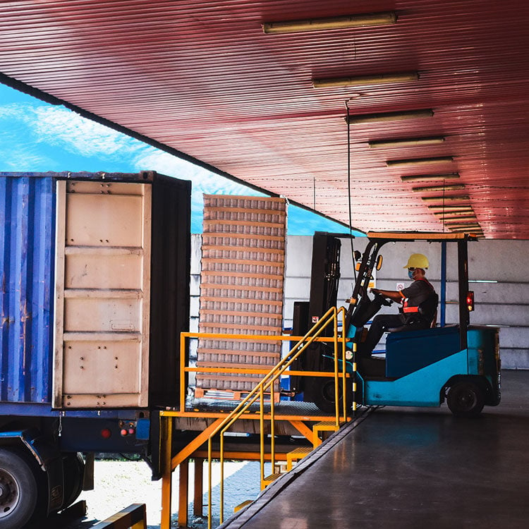 A worker uploading cargo to a company truck.