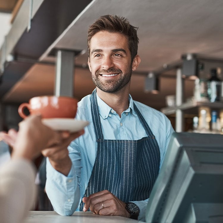 A man serving a customer at a counter.